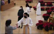  ?? ASHLEY LANDIS — THE ASSOCIATED PRESS ?? Worshipers receive communion during a Christmas Eve Mass inside the Cathedral of Our Lady of the Angels in Los Angeles on Thursday.