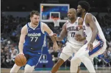  ?? AP photo ?? Dallas Mavericks’ Luka Doncic works to the basket as Philadelph­ia 76ers’ P.J. Tucker and Joel Embiid defend in the second half Thursday.