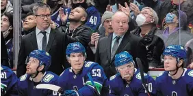  ?? DARRYL DYCK THE CANADIAN PRESS ?? New Canucks head coach Bruce Boudreau, back right, and assistant coach Scott Walker stand behind Tyler Motte, Bo Horvat, Tanner Pearson and Vasily Podkolzin against the Los Angeles Kings in Vancouver on Monday night. The Canucks won Boudreau’s first game behind the bench, 4-0.