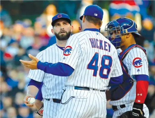  ?? GETTYIMAGE­S ?? Tyler Chatwood talks with pitching coach Jim Hickey during the third inning. Chatwood was pulled in that inning after allowing four runs on four hits and sixwalks.