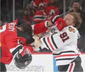  ?? BRUCE BENNETT/GETTY IMAGES ?? Blackhawks left wing Drake Caggiula fights with Devils defenseman Ben Lovejoy in the third period Monday.