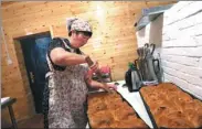  ?? WANG ZHUANGFEI / FOR CHINA DAILY ?? A woman prepares food for Russian tourists in a folk village in Inner Mongolia.