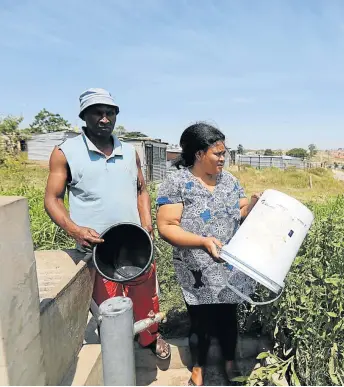  ?? Picture: ALAN EASON ?? DRY TIMES: NU1 residents Nkululeko Ndzendze, left, and Faniswa Tildini stand next to an ablution facility and tap where water supply ran dry by about 10am due to the BCM strike .