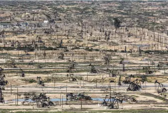  ?? Santiago Mejia / The chronicle ?? Drilling rigs pump in a vast oil field in Bakersfiel­d, one of the prime areas in the state that contribute to making California the nation’s third-biggest producer of onshore oil.