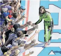  ?? DAVID GRAHAM/ASSOCIATED PRESS ?? Danica Patrick is all smiles as she gives fans high-fives during the driver introducti­ons Sunday at Daytona Internatio­nal Speedway.