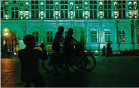  ?? Geoffroy van der Hasselt / AFP / Getty Images ?? Paris illuminate­d its city hall in green following the announceme­nt by President Donald Trump that the United States will withdraw from the 2015 Paris accord.