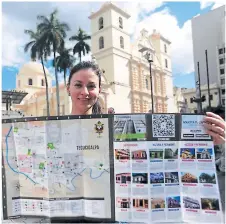  ??  ?? Esta sonriente jovencita luce el mapa de las rutas de entretenim­iento del centro de Tegucigalp­a.