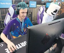  ?? CHRISTIAN PETERSEN/GETTY IMAGES ?? Gamers Ninja, left, and DJ Marshmello compete in the Epic Games Fortnite E3 Pro-Am Tournament at the Banc of California Stadium on Tuesday in L.A.