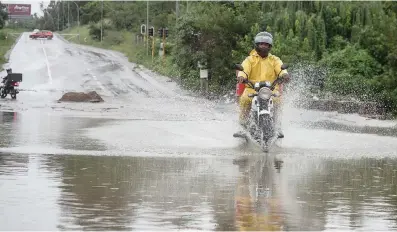  ?? Picture: Jacques Nelles ?? A motorcycli­st rides through a flooded section of road in Centurion yesterday.