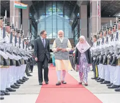  ??  ?? Indian PM Narendra Modi, centre, Malaysian Deputy PM Wan Azizah Wan Ismail, centre right, and Anwar Ibrahim, centre left, walk together in Sepang on Thursday.