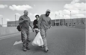  ?? Joe Amon,The Denver Post ?? Rene Lima-Marin walks away from the Aurora ICE detention facility with his father, Eli Borges, and wife, Jasmine, on Monday after winning his case before the board of immigratio­n appeals.