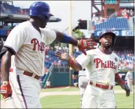  ?? Chris Szagola / Associated Press ?? The Phillies’ Jimmy Rollins, right, celebrates scoring a run with Ryan Howard against the Mariners in 2014. When Rollins made his first All-Star team as a rookie with the Phillies 20 years ago, the percentage of Black players in the majors was 13. It’s down to 7.6% this year.