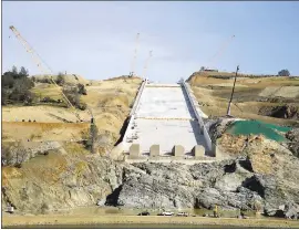  ?? PHOTOS BY RICH PEDRONCELL­I — THE ASSOCIATED PRESS ?? Cranes sit by the Oroville Damspillwa­y Thursday. California water officials and the constructi­on manager said that recently found hairline cracks on the spillway are normal.