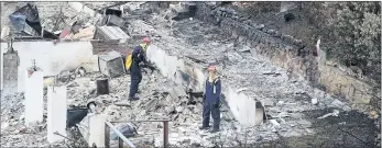  ??  ?? DEVASTATIN­G: Firefighte­rs keep an eye on possible outbreaks in Afrikander Road, Simon’s Town, where a raging mountain fire gutted four homes and damaged three others this week.