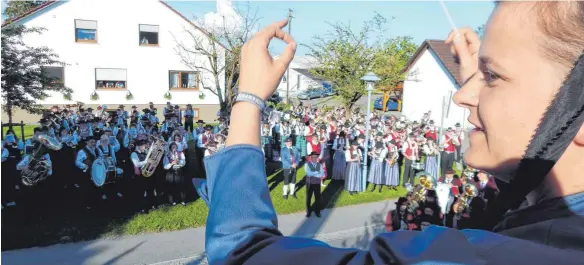  ?? FOTOS (2): WOLFGANG LUTZ ?? Christine Wetzel dirigiert den Gesamtchor am Samstag Abend in der Ortsmitte.