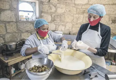  ?? Picture: AFP ?? LOCAL IS LEKKER. Assistant cheesemake­r Jeanet Mapula Mokwena, left, prepares fig-filled scamorza cheese with cheesemake­r Marietjie Crowther at a small artisanal dairy in Clarens last week.