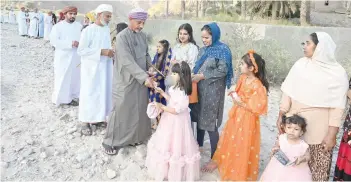  ?? PHOTOS BY KHALFAN AL RUZAIQI ?? Elders exchange Eidia with children in Al Amerat on Wednesday.