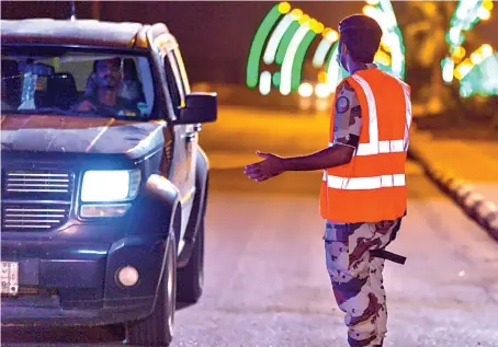  ?? SPA ?? Security official enforcing the curfew to limit the spread of coronaviru­s check a motorist in the Baish governorat­e of Jazan region on Wednesday.