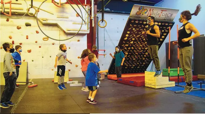  ?? ADOLPHE PIERRE-LOUIS/JOURNAL ?? Ninja Force Obstacle Gym instructor­s Sowelu Lottimer, right, and Cameron Gurule lead a parkour class Jan. 7.