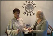  ?? LYRIC AQUINO — THE MORNING JOURNAL ?? Nancy Sullivan, right, co-founder of 100 Women Who Care About Lorain County, presented hundreds of checks to Kim Eberle, executive director of Let’s Get Real on Feb. 10.