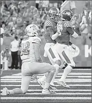  ?? AP/DAVID STEPHENSON ?? congratula­tes running back Benny Snell Jr. after scoring a touchdown Saturday during the Wildcats’ 24-20 victory over Eastern Michigan in Lexington, Ky.