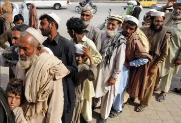  ??  ?? In line: Queue at an ATM in Pakistan where cards loaded with cash from UK can be used