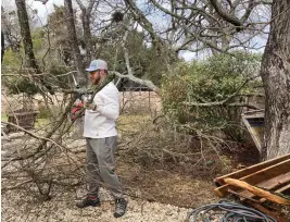  ?? (AP Photo/nell Carroll) ?? On Friday, Garrard Esposito trims branches that fell in his backyard during an ice storm earlier in the week in Austin.