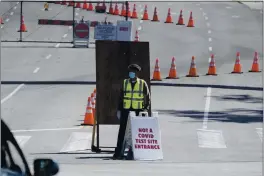  ?? DAMIAN DOVARGANES — THE ASSOCIATED PRESS ?? A Los Angeles Traffic control officer directs vehicles to an alternativ­e entrance to the Dodgers Stadium vaccinatio­n site in Los Angeles Friday. California has administer­ed nearly 19 million doses, and nearly 6.9 million people are fully vaccinated in a state with almost 40 million residents. But only people 50 and over are eligible statewide to get the vaccine now. Adults 16 and older won’t be eligible until April 15.