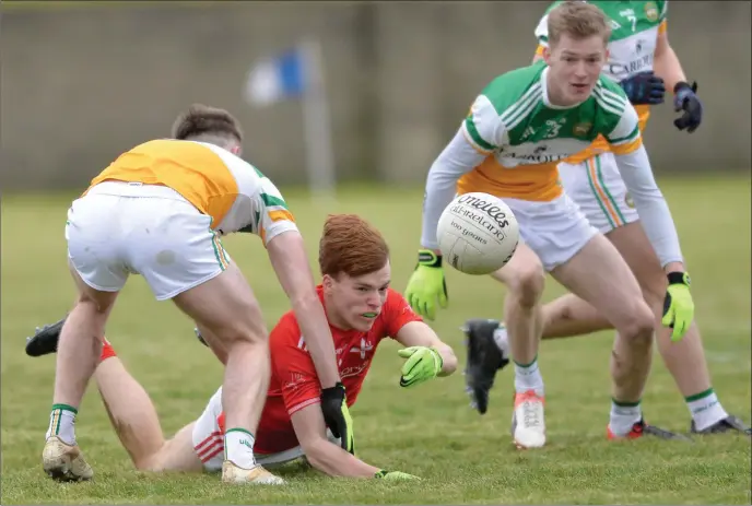  ?? Pictures: Ken Finegan ?? Ciaran Keenan of Louth gets the ball away despite close attention from Offaly players.