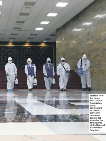  ?? AFP ?? Workers from the Korea Pest Control Associatio­n spray disinfecta­nt as part of preventive measures against the spread of the coronaviru­s, at the National Assembly in Seoul