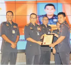  ??  ?? Wan Mohd Nor (second left) presents an award to a Bomba officer, witnessed by (from left) Nor Hisham, Mohammad Hamdan and Mohd Ali.