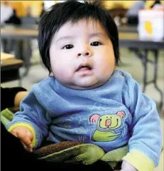  ??  ?? A member of 3-month-old Martin Emilio Marroquin’s family waits to speak with a lawyer Feb. 18 at a clinic held at Casa San Jose in Brookline, a resource center for the Latino community.