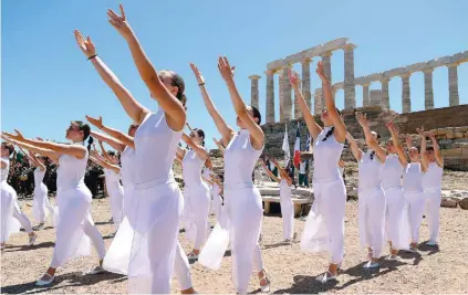  ?? ?? Performers welcome the Olympic Flame at the Temple of Poseidon in Sounio on Friday, which was the 11th day of the Torch Relay and the last the powerful symbol of the Games spent on Greek soil before heading to Paris after a tour of Attica.