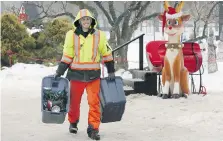  ?? NICK BRANCACCIO ?? Electricia­n Matt Deschamps of Tucker Electric carries spotlights as crews on Wednesday disassembl­ed thousands of lights and extension cords at Jackson Park, part of the cleanup following the inaugural Bright Lights Windsor festival.