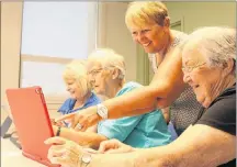  ?? MILLICENT MCKAY/JOURNAL PIONEER ?? Jean Poirier, from left, Carolyn Taylor, and Dorothy Farish, right, receive a technology lesson from EPSI Computer Club volunteer, Shelley Lively (standing).