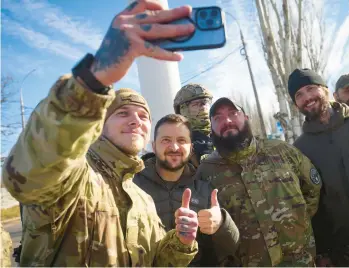  ?? UKRAINIAN PRESIDENTI­AL PRESS OFFICE ?? Volodymyr Zelenskyy, center, poses with Ukrainian soldiers Monday in Kherson.