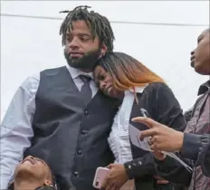  ?? Steve Mellon/Post-Gazette ?? Michael Rouse comforts his fiancee, Khadiyjah Cook, after a balloon release honoring Mr. Rouse’s brother, Christian Moore-Rouse, on March 11 at Mulberry Community Church in Wilkinsbur­g. On Tuesday, Allegheny County police charged Adam Rosenberg in Mr. Moore-Rouse’s death.