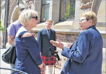  ?? CAROL DUNN/THE NEWS ?? Cindy D’Aoust and Lane West of Cruise Lines Internatio­nal Associatio­n pose with piper Tyler Cameron outside of New Glasgow’s town hall.