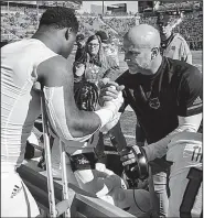  ?? Arkansas Democrat-Gazette/MITCHELL PE MASILUN ?? Ronheen Bingham gets some encouragem­ent from defensive line coach Brian Early (right) after suffering a medial collateral ligament injury to his left knee during the first quarter of the Red Wolves’ loss to Nevada on Saturday. Bingham expects to undergo surgery Monday.