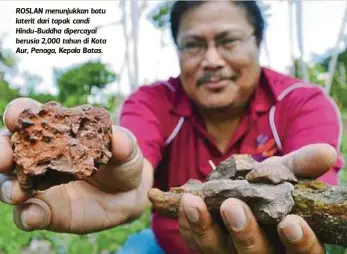  ??  ?? ROSLAN menunjukka­n batu laterit dari tapak candi Hindu-Buddha dipercayai berusia 2,000 tahun di Kota Aur, Penaga, Kepala Batas.