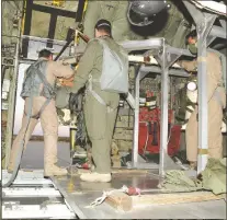  ??  ?? LEFT: The aluminum deployment rack are loaded into the cargo bay of a C-17. The deployment rack allows the air crew to move and deploy the mannequins by means of a large crank, ensuring a safe and uniform drop from the aircraft. BELOW: Testing personnel receive a safety briefing inside the cargo bay of a C-17. They will be deploying the T-11 test parachutes from the aircraft.