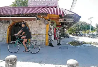  ?? Photos by Kevin Sieff / Washington Post ?? Security forces stand outside a bar in Tulum, Mexico, where gunmen killed two tourists in October. Recently, some tourist spots along Mexico’s Caribbean coast have been hit with violence.