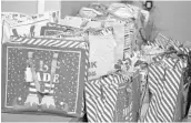  ??  ?? These bags full of wrapped gifts will brighten the Christmas season for the homeless children at Covenant House.