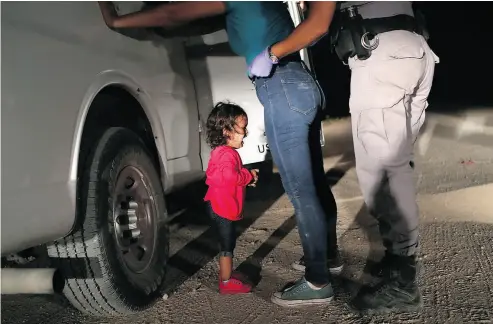  ?? JOHN MOORE/GETTY IMAGES ?? A two-year-old Honduran asylum seeker cries as her mother is searched and detained near the U.S.-Mexico border this week in McAllen, Texas. The asylum seekers rafted across the Rio Grande from Mexico and were detained by U.S. Border Patrol agents...