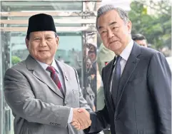  ?? AFP ?? Indonesian Defence Minister and President-elect Prabowo Subianto, left, and China’s Foreign Minister Wang Yi, right, pose for a photo in Jakarta, yesterday.