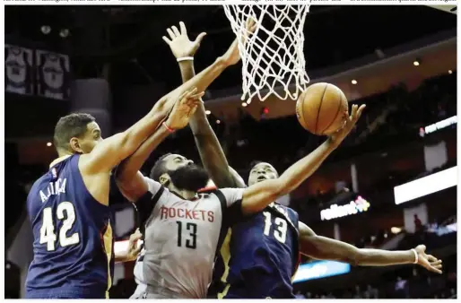  ??  ?? Houston Rockets’ James Harden (13) is fouled as he goes up for a shot between New Orleans Pelicans’ Alexis Ajinca (42) and Cheick Diallo (13) during the second half of an NBA basketball game Friday in Houston. (AP)