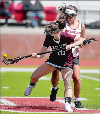  ?? SARAH GORDON/THE DAY ?? East Lyme´s Abbie Belleville (15) scoops up a loose ball in front of NFA’ss Jayna Neault (2) during Tuesday’s ECC Division I girls’ lacrosse game at Norwich. The Vikings rolled to a 21-2 victory.