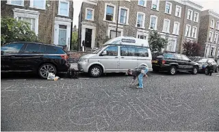  ?? VICTORIA JONES THE ASSOCIATED PRESS ?? A protester writes a message outside the north London home of Dominic Cummings, British Prime Minister Boris Johnson’s chief aide, on Sunday.