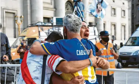  ?? Foto: Ferrario, imago ?? Sich gegenseiti­g Halt geben. Argentinis­che Fußballfan­s beweinen den Tod ihres Idols Diego Maradona, der im Alter von 60 Jahren gestorben ist.
