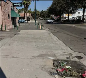  ?? NEWS-SENTINEL PHOTOGRAPH­S BY JOHN BAYS ?? Left: Flowers rest at the scene where Gerardo De Santiago, 35, and Brian Soto, 21, were shot and killed early on Sunday morning in Lodi. Police are continuing to investigat­e the fatal shooting. Below: A sign left at the makeshift memorial for the two men reads, “When someone you love becomes a memory, that memory becomes a treasure.”